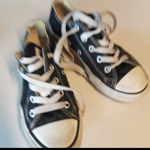 Girls black converse sneakers.